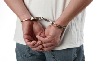 Criminal in handcuffs representing online crime